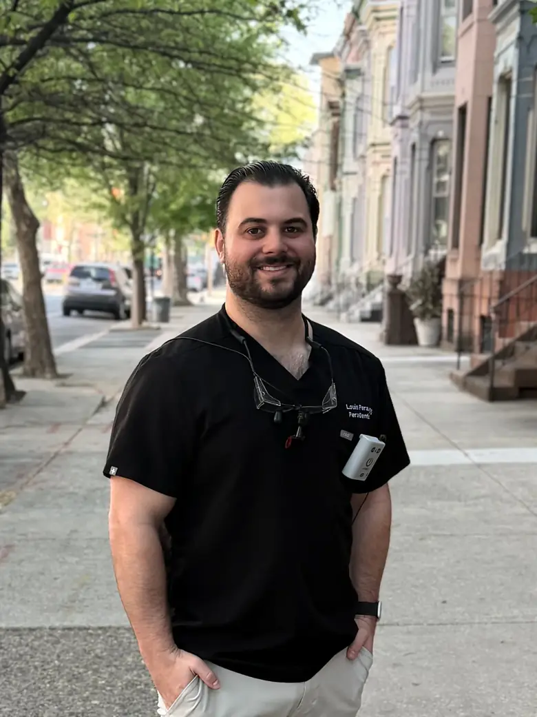 Dr. Louis Pera in dental scrubs